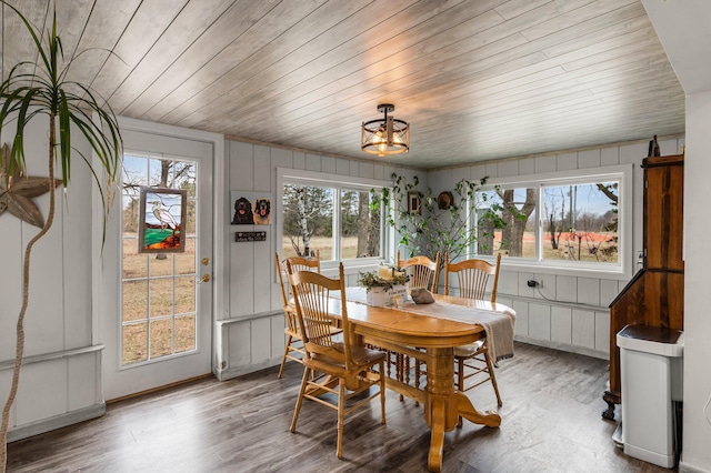 dining space featuring light wood-type flooring, wooden ceiling, and an inviting chandelier