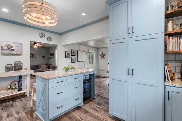 kitchen with dark wood finished floors, beverage cooler, light stone countertops, crown molding, and open floor plan
