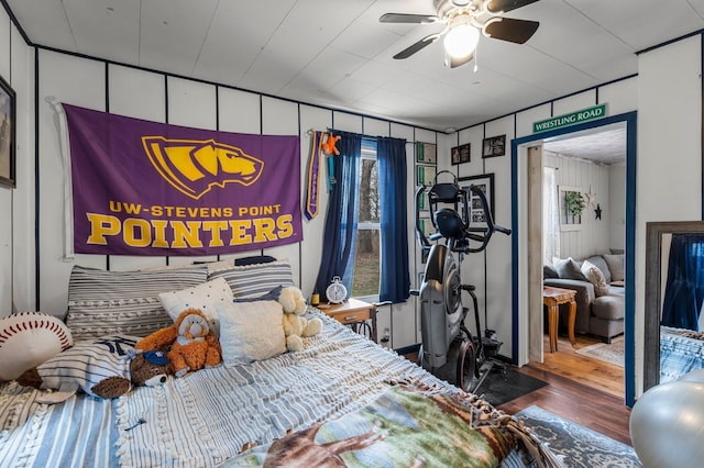bedroom featuring ceiling fan, multiple windows, and wood finished floors