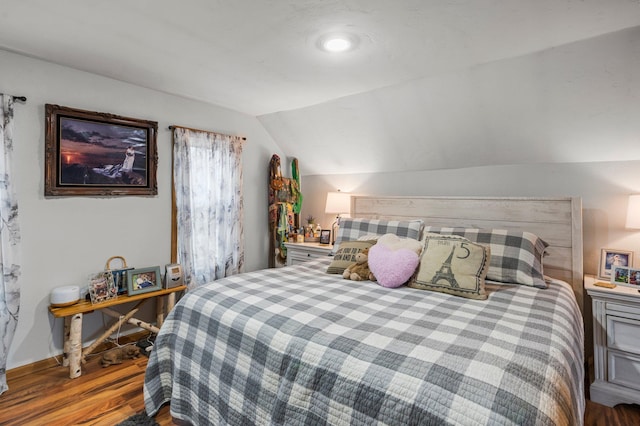 bedroom featuring lofted ceiling and wood finished floors