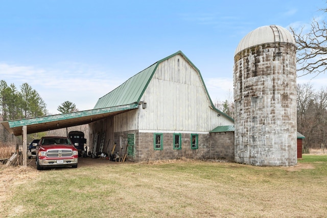 view of barn with a lawn and a carport