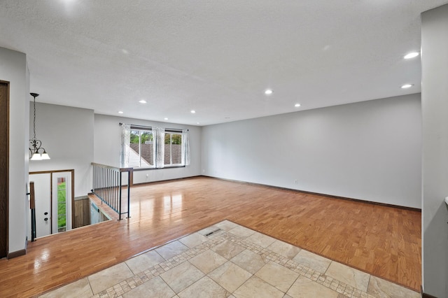 11560 Red Fox Dr, Maple Grove, MN 55369 - empty room featuring wood finished floors, recessed lighting, inlaid floor details, baseboards, and a chandelier