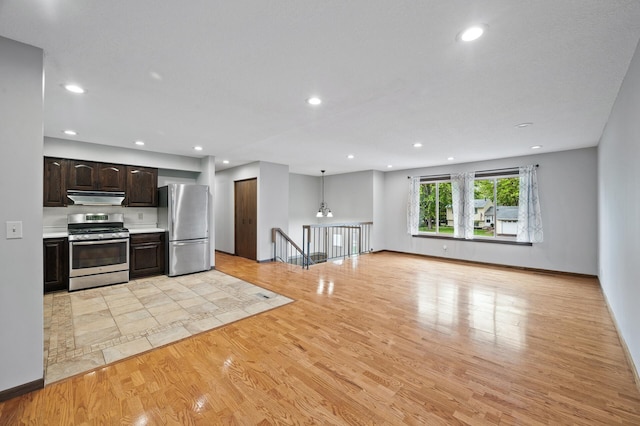 11560 Red Fox Dr, Maple Grove, MN 55369 - kitchen featuring stainless steel appliances, under cabinet range hood, light wood-style floors, dark brown cabinetry, and recessed lighting