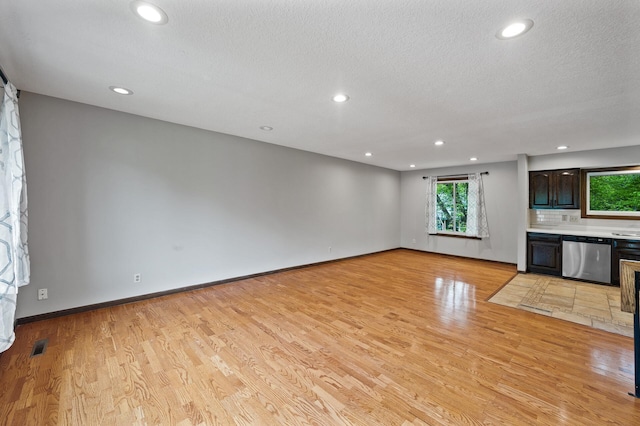 11560 Red Fox Dr, Maple Grove, MN 55369 - unfurnished living room featuring light wood-style flooring, recessed lighting, baseboards, and a textured ceiling