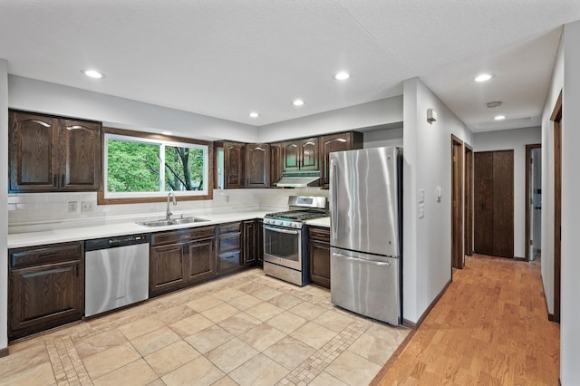 11560 Red Fox Dr, Maple Grove, MN 55369 - kitchen with appliances with stainless steel finishes, a sink, under cabinet range hood, dark brown cabinetry, and recessed lighting