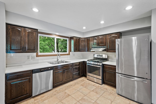 11560 Red Fox Dr, Maple Grove, MN 55369 - kitchen featuring stainless steel appliances, a sink, under cabinet range hood, dark brown cabinets, and light countertops
