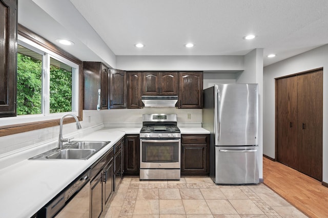11560 Red Fox Dr, Maple Grove, MN 55369 - kitchen with stainless steel appliances, under cabinet range hood, a sink, dark brown cabinets, and light countertops