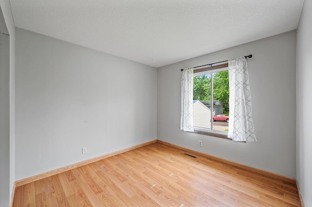 11560 Red Fox Dr, Maple Grove, MN 55369 - spare room with wood finished floors, baseboards, and a textured ceiling