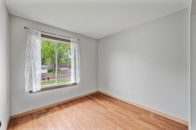 11560 Red Fox Dr, Maple Grove, MN 55369 - empty room featuring wood finished floors, baseboards, and a textured ceiling