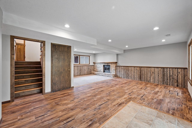 11560 Red Fox Dr, Maple Grove, MN 55369 - unfurnished living room with wood finished floors, a wainscoted wall, a fireplace, recessed lighting, and wooden walls