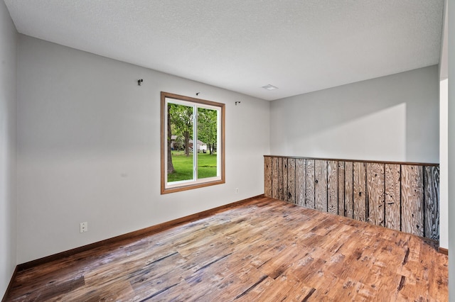 11560 Red Fox Dr, Maple Grove, MN 55369 - spare room with wood finished floors, baseboards, and a textured ceiling