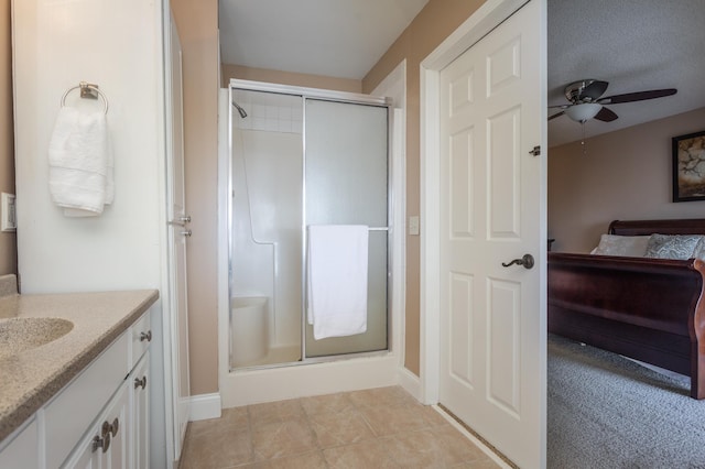 full bath featuring vanity, baseboards, ceiling fan, connected bathroom, and a shower stall