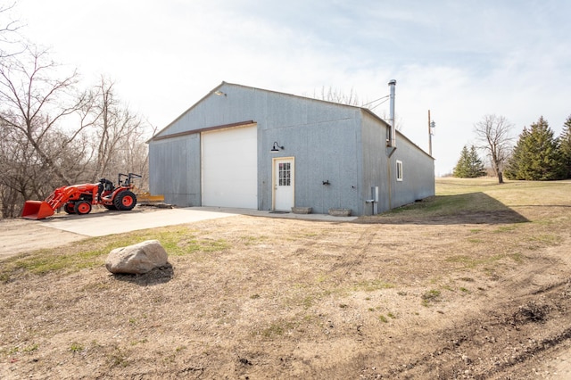 view of outdoor structure with driveway and an outbuilding