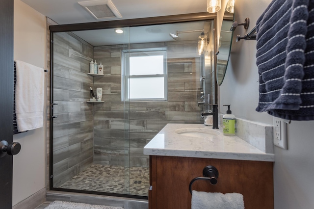 full bath with vanity, visible vents, and a stall shower