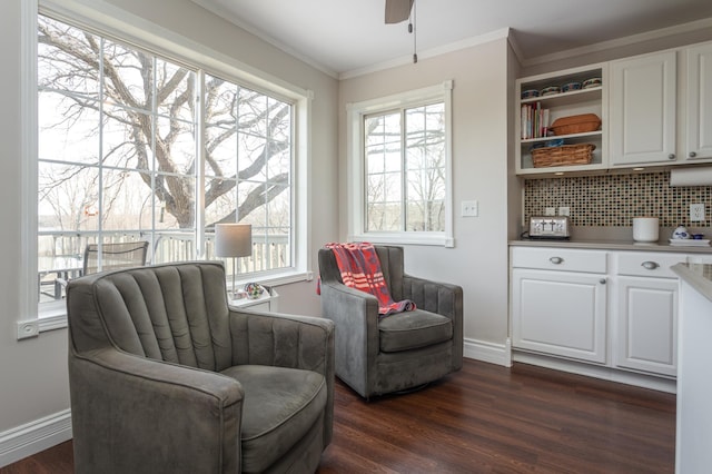 living area with crown molding, ceiling fan, dark wood-style floors, and a healthy amount of sunlight