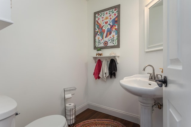 bathroom featuring baseboards, toilet, and wood finished floors