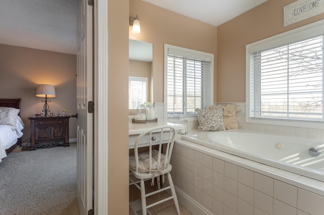 ensuite bathroom with a wealth of natural light, a bath, and ensuite bath