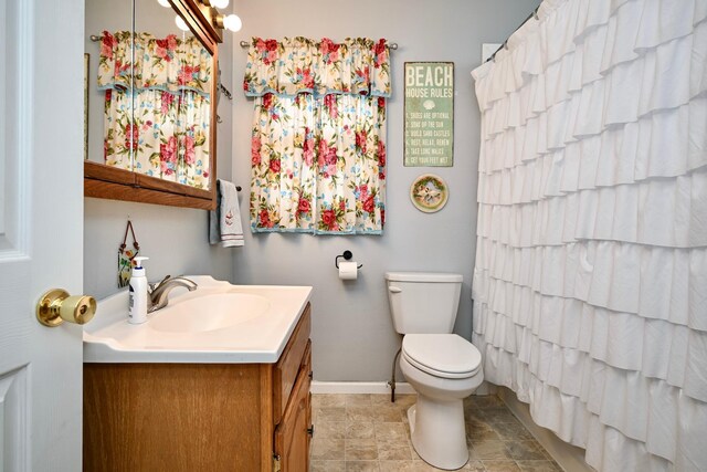 full bathroom with baseboards, vanity, and toilet