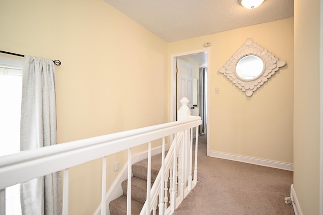 corridor featuring baseboards and carpet flooring