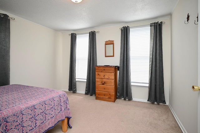 bedroom featuring crown molding, a textured ceiling, carpet flooring, and baseboards