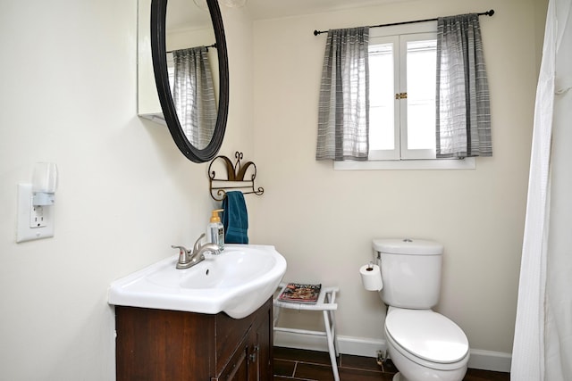 bathroom with vanity, toilet, and baseboards