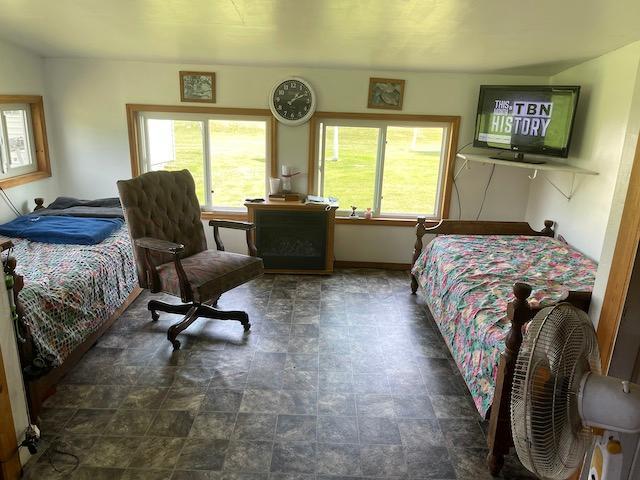 bedroom featuring stone finish floor and baseboards
