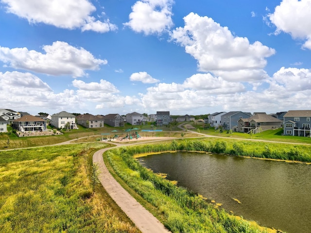 view of property's community featuring a yard, a residential view, and a water view