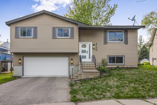 bi-level home featuring a garage, driveway, and entry steps