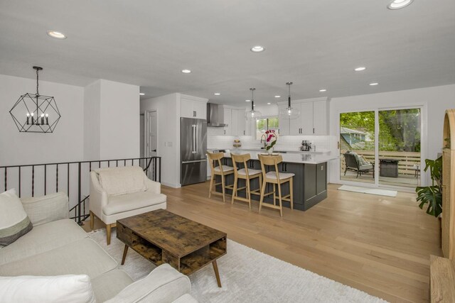 living room with a chandelier, recessed lighting, and light wood finished floors