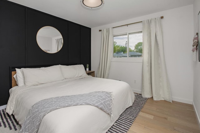 bedroom with light wood-style floors and baseboards