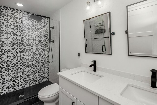 full bathroom with toilet, a tile shower, and double vanity