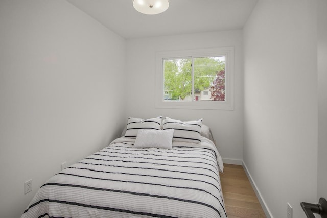 bedroom with light wood-style floors and baseboards