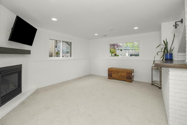 unfurnished living room with a fireplace, carpet, wainscoting, and recessed lighting