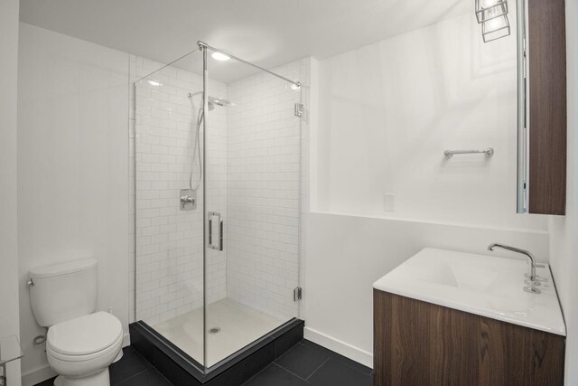 full bath featuring a shower stall, toilet, tile patterned floors, baseboards, and vanity