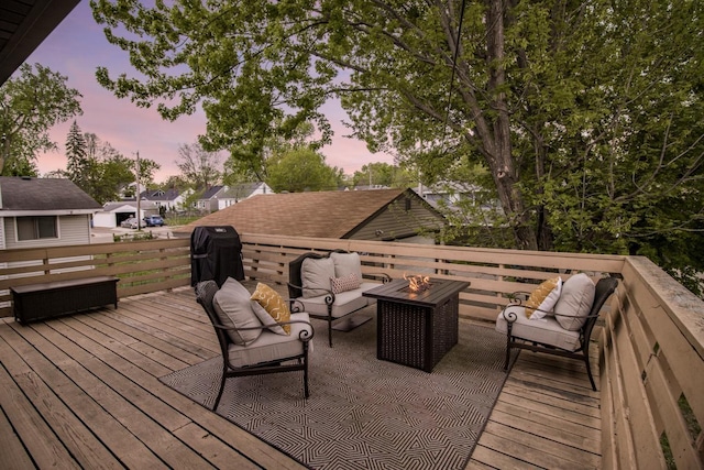 deck at dusk featuring an outdoor living space with a fire pit