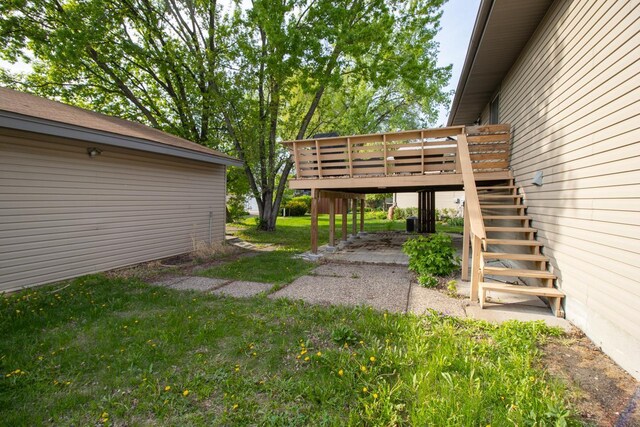 view of grassy yard with stairway and a wooden deck