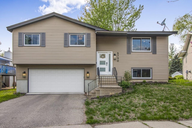 5750 Thomas Cir S, Minneapolis, MN 55410 - bi-level home with a garage, asphalt driveway, entry steps, and a front yard
