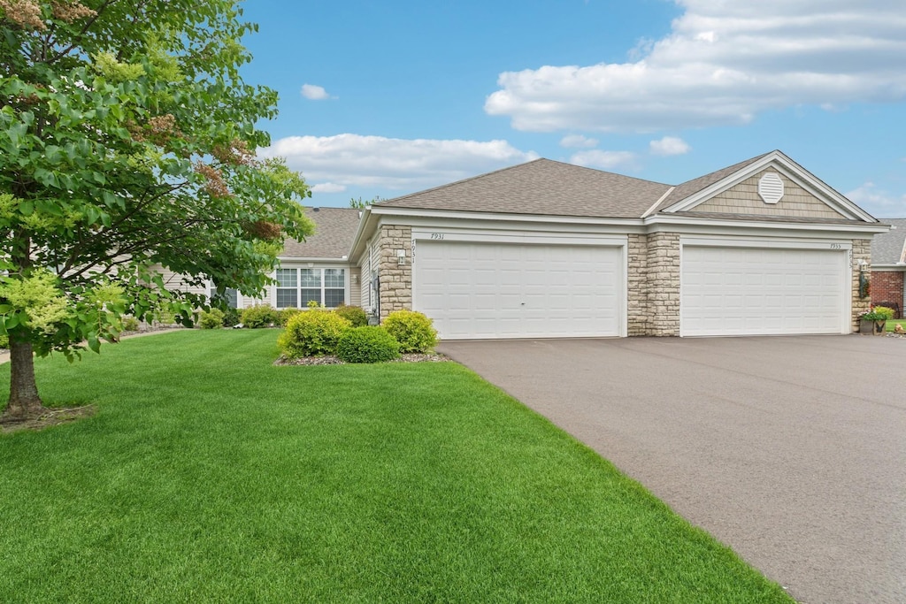 7931 Pinnacle Ave NE, Otsego, MN 55330 - ranch-style house with asphalt driveway, stone siding, a garage, and a front yard