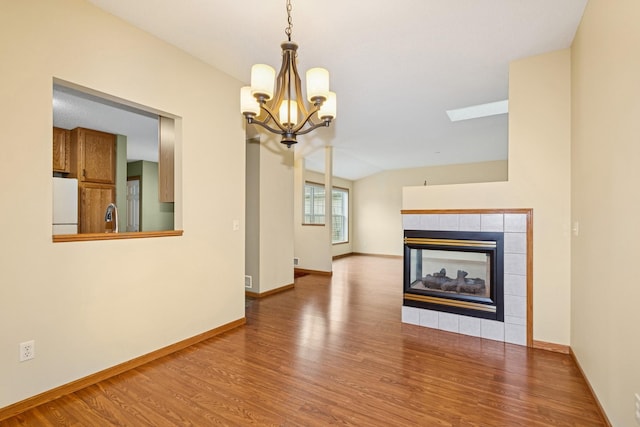 7931 Pinnacle Ave NE, Otsego, MN 55330 - unfurnished living room with a chandelier, wood finished floors, and a fireplace