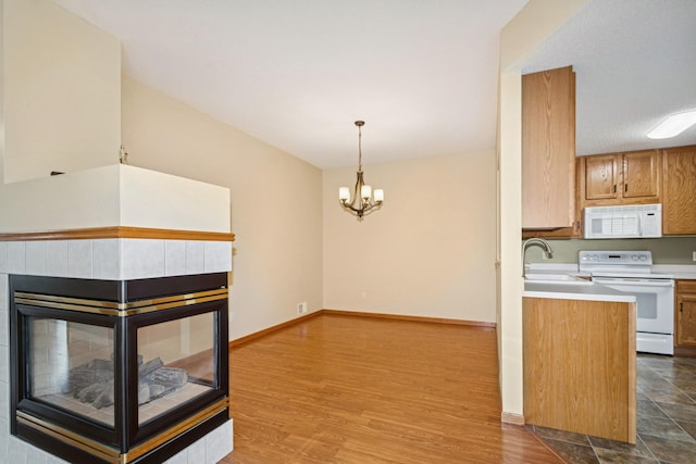 7931 Pinnacle Ave NE, Otsego, MN 55330 - kitchen featuring white appliances, brown cabinets, light countertops, a chandelier, and decorative light fixtures