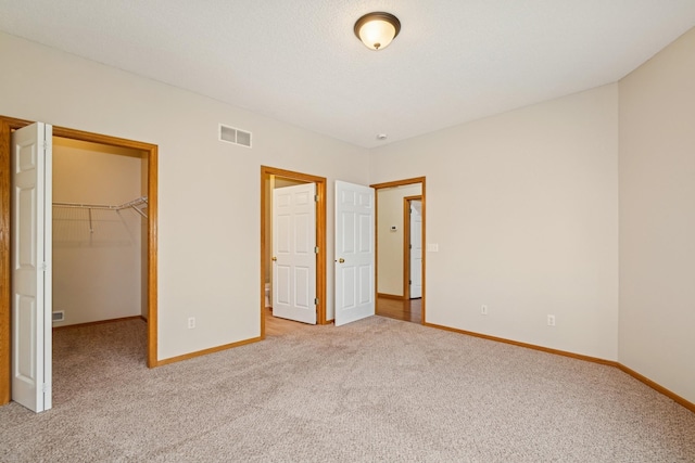 7931 Pinnacle Ave NE, Otsego, MN 55330 - unfurnished bedroom featuring carpet, a walk in closet, and a closet