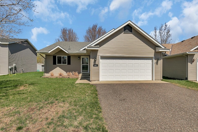 ranch-style home featuring a garage, driveway, and a front yard