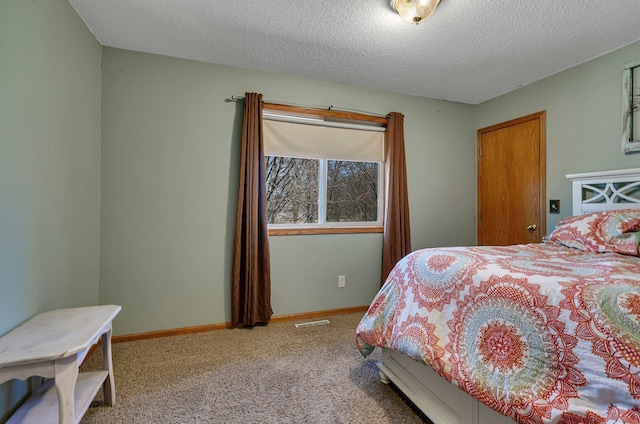 carpeted bedroom featuring baseboards, a textured ceiling, and visible vents