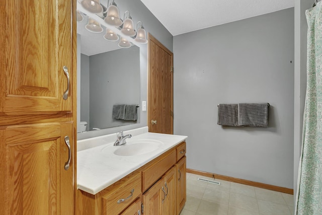 full bathroom with baseboards, vanity, toilet, and visible vents