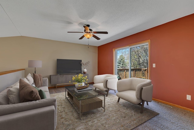 living room featuring baseboards, a ceiling fan, a textured ceiling, and visible vents