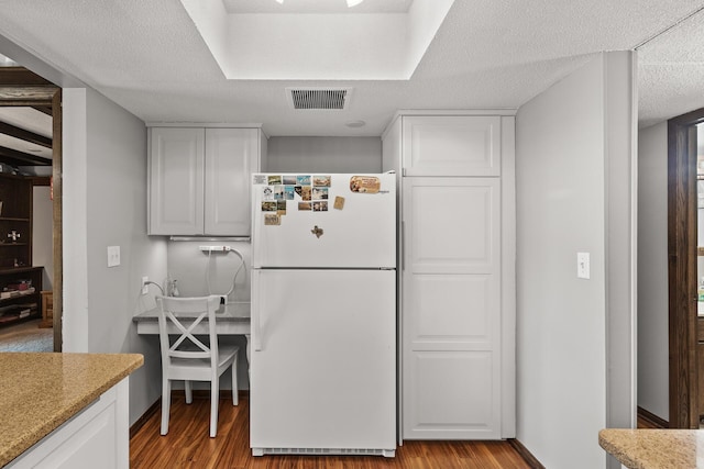 6085 Lincoln Dr Unit 122, Edina, MN 55436 - kitchen featuring white cabinets, visible vents, freestanding refrigerator, light wood-type flooring, and baseboards