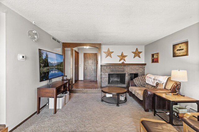 6085 Lincoln Dr Unit 122, Edina, MN 55436 - living room featuring visible vents, a fireplace, arched walkways, a baseboard radiator, and carpet flooring
