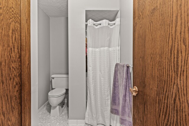 6085 Lincoln Dr Unit 122, Edina, MN 55436 - full bathroom with curtained shower, a textured ceiling, tile patterned flooring, and toilet