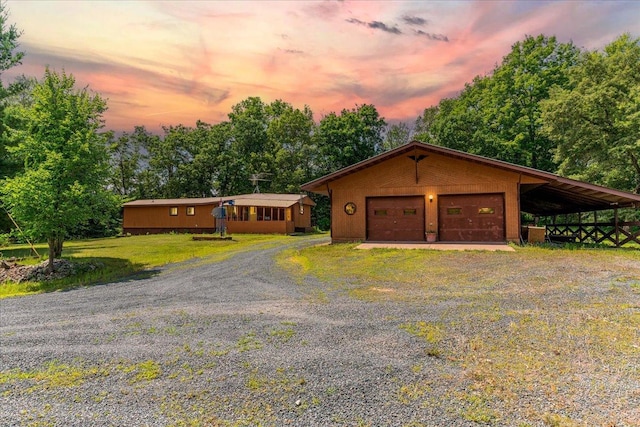 view of front of property featuring a yard, an outdoor structure, and a garage