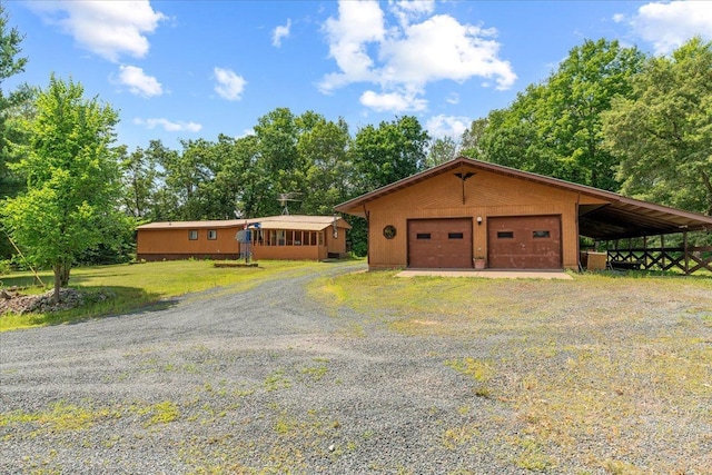 view of front of property with a garage, a front lawn, and an outbuilding